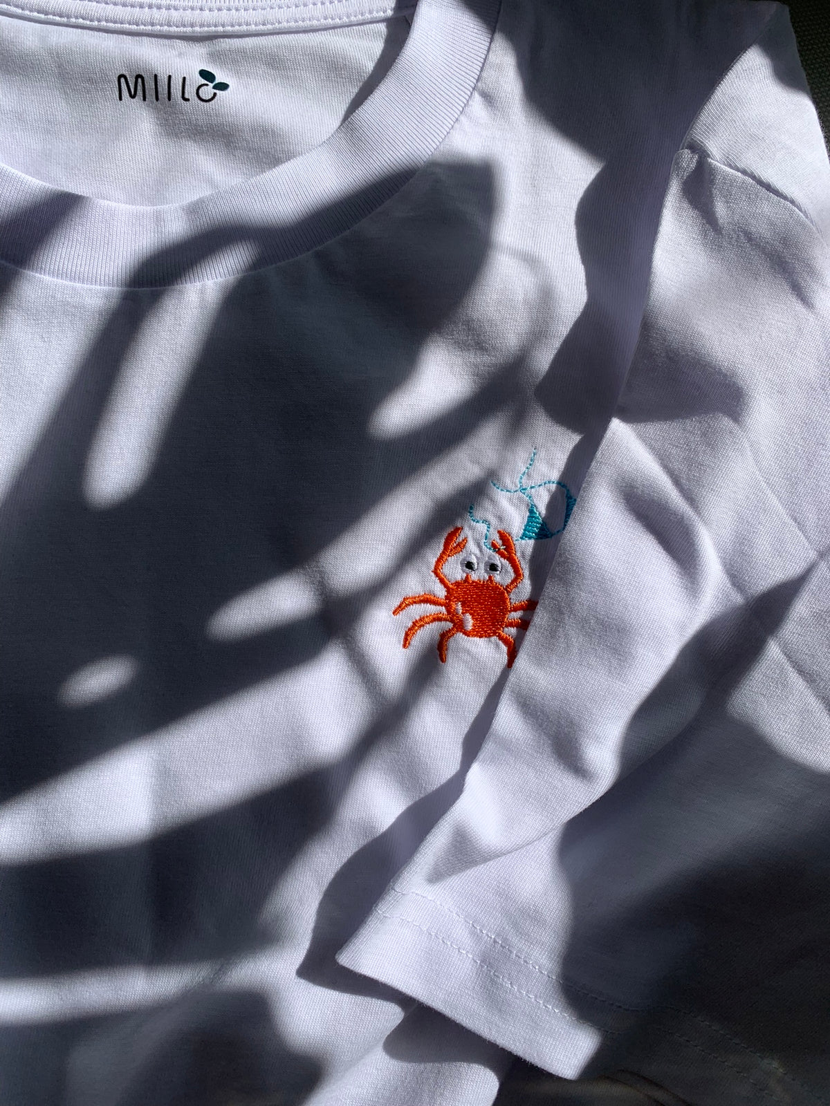 white short-sleeve vneck medium fit t-shirt with a small embroidered red crab on the chest